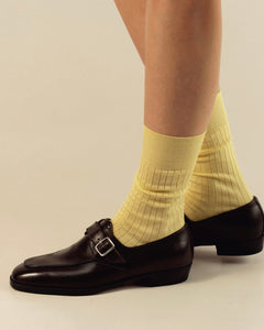 Woman wearing monk strap moccasins styled with ribbed socks for a modern, refined look